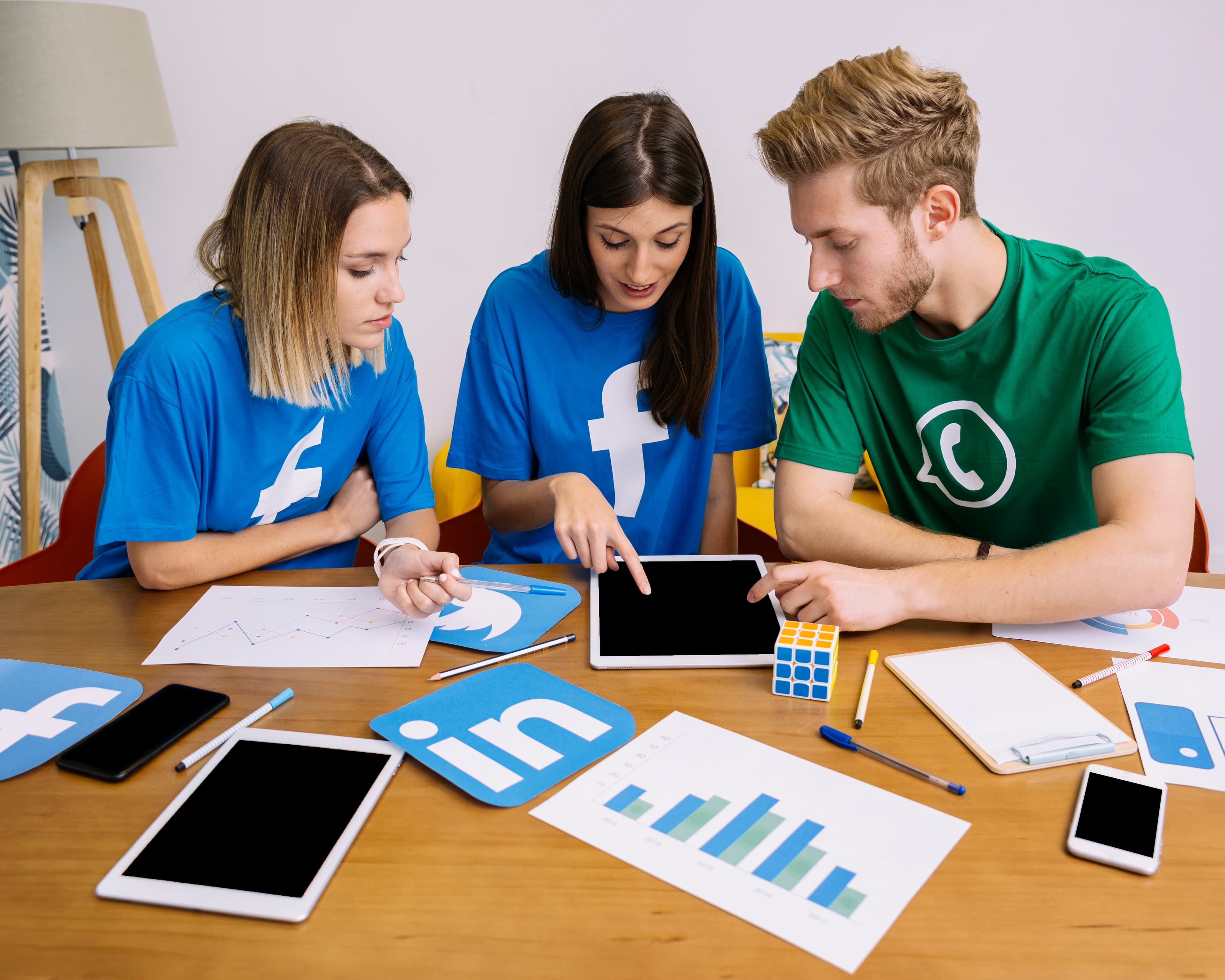 A marketing team reviewing paid social campaign results on a tablet, with performance charts on the table.
